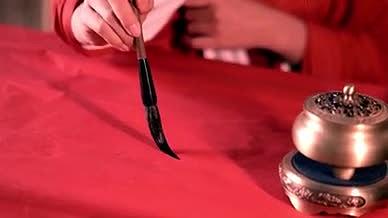 4k实拍毛笔在红纸上写新年福字视频的预览图